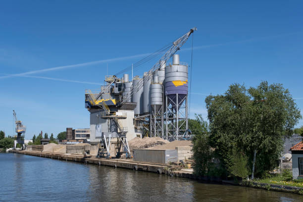 istock Bulk-handling crane unloading sand, road metal and gravel from cargo vessel ship 1256071623