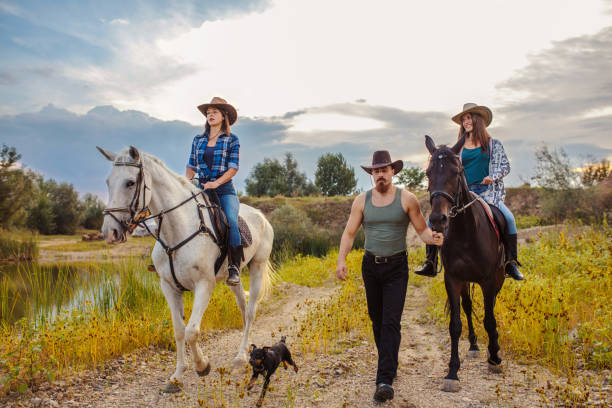 istock Two young women with instructor enjoy riding horses in nature 1256073425