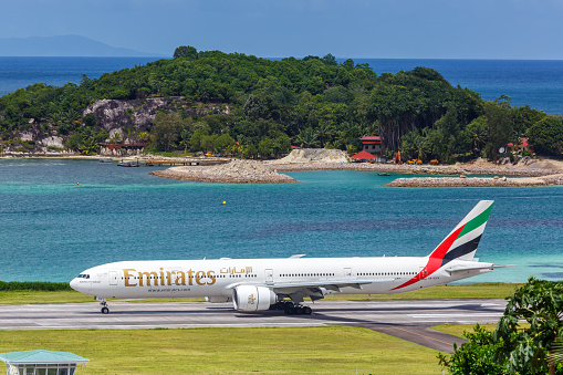 Mahe, Seychelles – February 9, 2020: Emirates Boeing 777-300ER airplane at Mahe airport (SEZ) in the Seychelles. Boeing is an American aircraft manufacturer headquartered in Chicago.