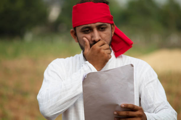 istock Stressed farmer reading contract on agricultural field 1256079618