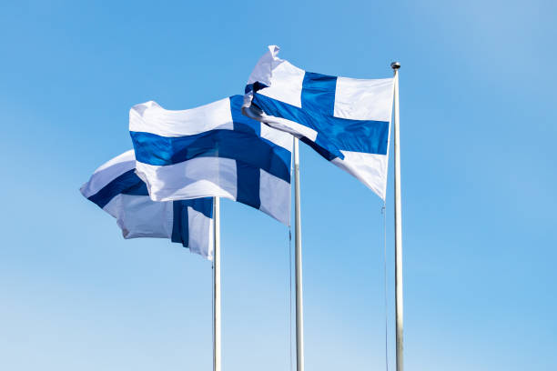 istock Three finnish national flags on the wind against the blue sky 1256079865