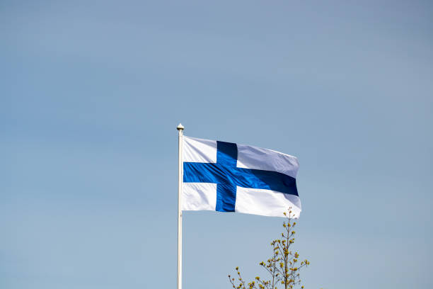 istock Finnish national flag on the wind against the blue sky 1256079904