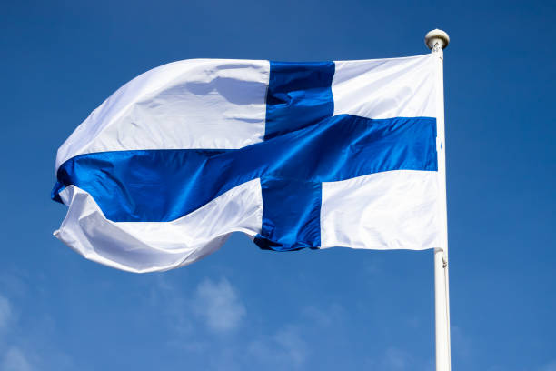 istock Finnish national flag on the wind against the blue sky 1256079913