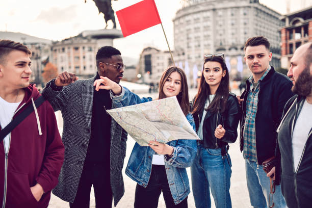 istock Tourists Sightseeing Through City With Map 1256081718