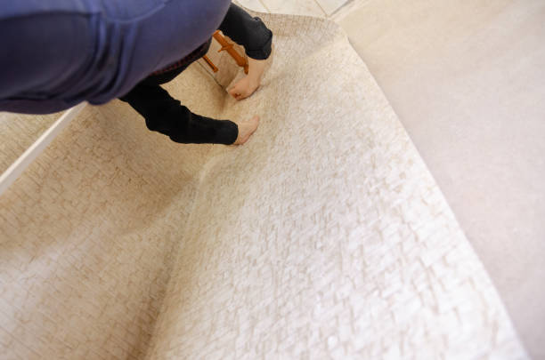 istock Woman gluing light Wallpaper, bottom view. Repairing flat 1256082984