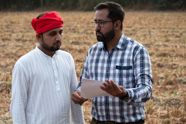 istock Salesman explaining contract farming agreement to farmer on field 1256083120