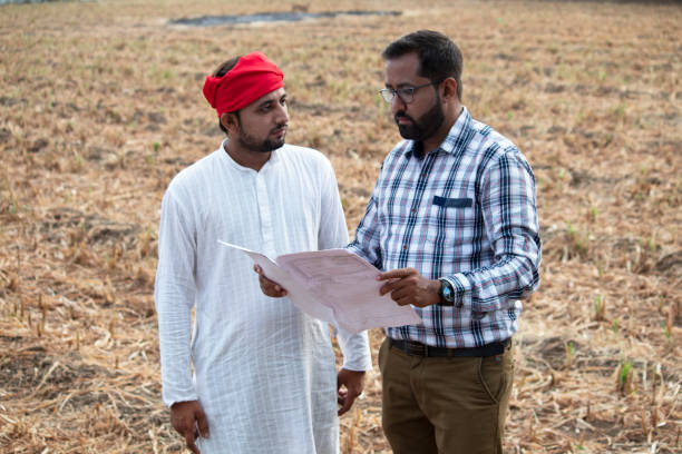 istock Salesman explaining contract farming agreement to farmer on field 1256083546