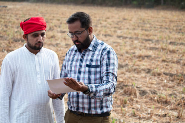 istock Salesman explaining contract farming agreement to farmer on field 1256084757