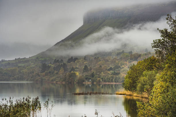 Low clouds above Glencar Lough (lake) Low clouds above Glencar Lough (lake) with the iconic Benbulbin mountain rising in the background conveys relax, calm and joyful concept. Environmental illustration - County Sligo, Ireland ben bulben stock pictures, royalty-free photos & images