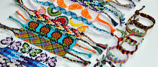 istock Woven friendship bracelets with alpha and normal patterns handmade of thread on white background.  tied and untied bracelets 1256087969
