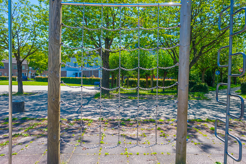 Playground of a school with playground equipment for children to play with in bright sunlight in summer, Almere, Flevoland, The Netherlands, July 12, 2020