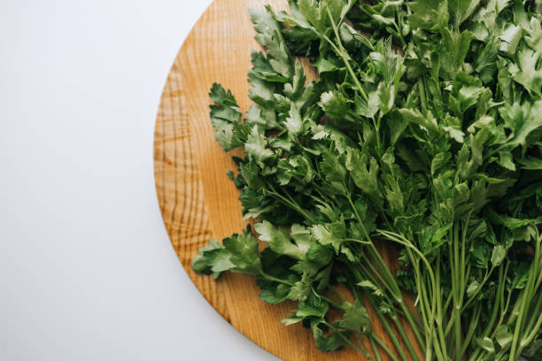 istock Green parsley on a wooden board, white background. Proper nutrition. Flat lay 1256089185