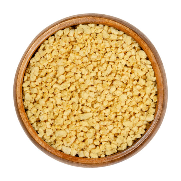 Soya granules, textured soy protein, soy meat in wooden bowl Soya granules in wooden bowl. Textured soy protein, also called soy meat. Defatted soy flour product, used as meat analogue or meat extender. Closeup from above, over white, isolated macro food photo. tsp stock pictures, royalty-free photos & images