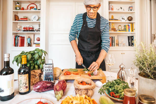 homem feliz pronto para cozinhar - cozinha mediterrânica - fotografias e filmes do acervo