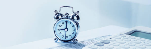 istock Alarm clock with calculator on financial paperwork 1256093159