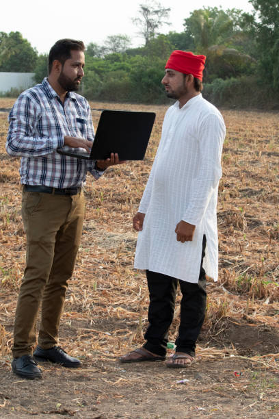 istock Engineer with farmer discussing on agricultural field 1256094285