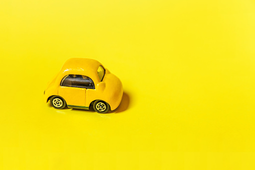 Simply design yellow vintage retro toy car isolated on yellow colorful background. Automobile and transportation symbol. City traffic delivery concept. Copy space