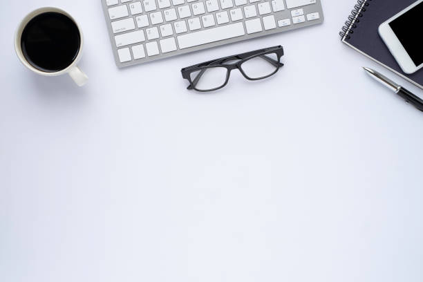 istock Top view above of White office desk table with keyboard, notebook and coffee cup with equipment other office supplies. Business and finance concept. Workplace, Flat lay with blank copy space. 1256095415