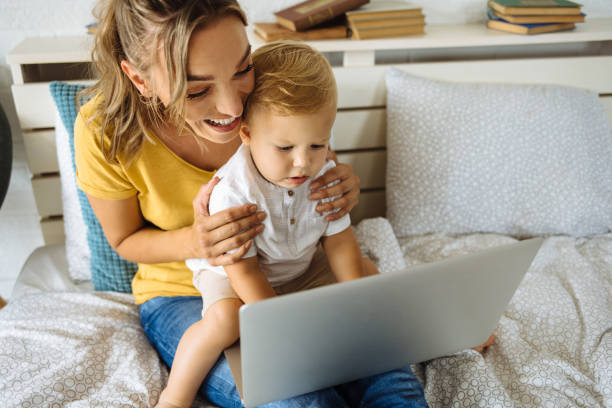 istock Caring mother and son using laptop on bed 1256096598