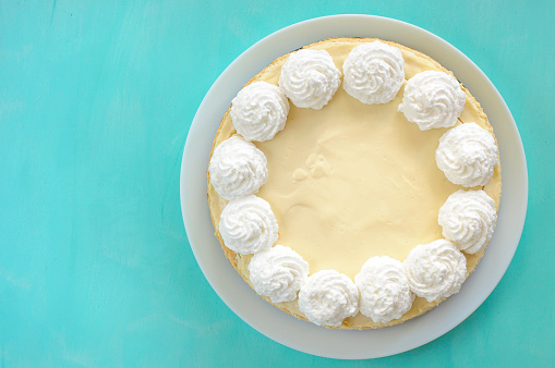 classic cheesecake on a white plate, decorated with cream