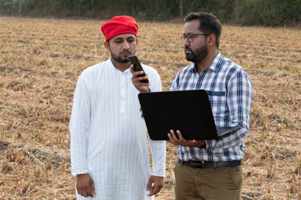 istock Farmer with businessman using mobile phone app 1256096929