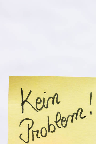 istock Kein problem (no problem)  handwriting text close up isolated on yellow paper with copy space. 1256096950