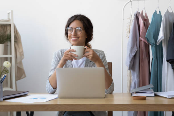 istock Smiling female drink coffee look in distance dreaming 1256097752