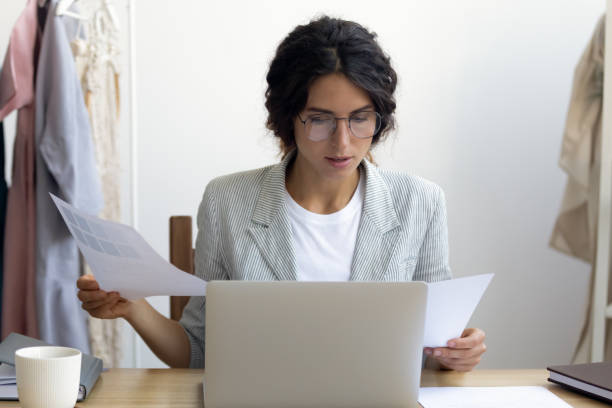 istock Young Caucasian businesswoman manage documents working on laptop 1256097766