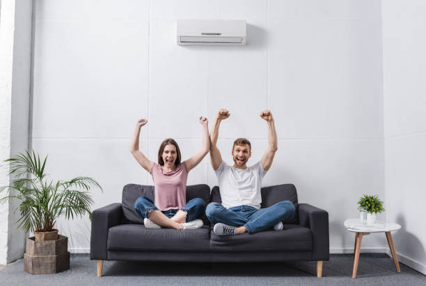 istock excited shouting couple at home with air conditioner 1256098119