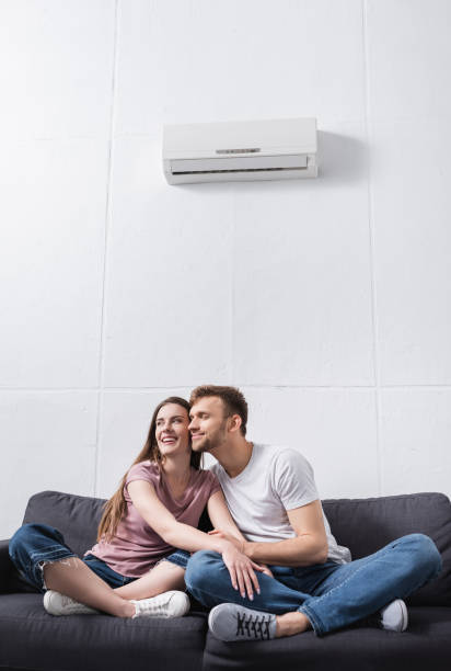 istock smiling couple hugging at home with air conditioner 1256098120