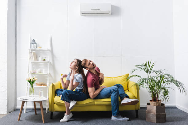 istock exhausted couple suffering from heat while sitting home with broken air conditioner 1256098137