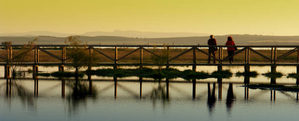 A couple is reflected in the water of the Fuente de Piedra Lagoon