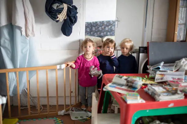 IVF triplets playing at home with their mother.