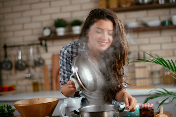 istock Young woman cooking at home 1256102822