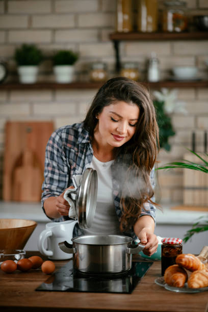 istock Young woman cooking at home 1256102831