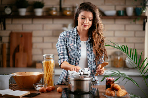istock Young woman cooking at home 1256102893
