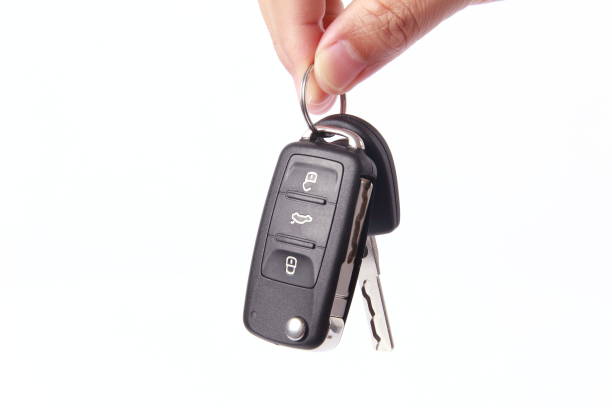 istock Man hand holding car key, isolated on white background 1256103155