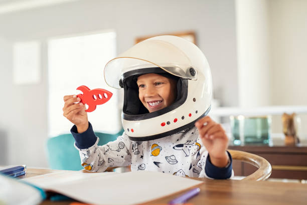 niño jugando con casco de astronauta y cohete - super moon fotografías e imágenes de stock