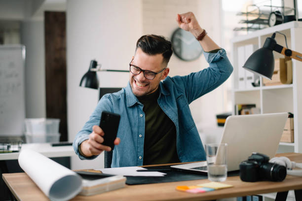 istock Handsome businessman talking to the phone while working in the office. 1256104044