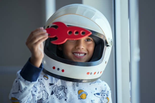 istock Child playing with astronaut helmet and toy rocket 1256104366