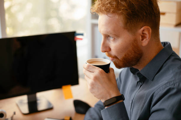 istock Businessman drinking coffee while working in the office. 1256104713