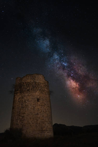 istock Milky way background beside an ancient tower 1256105544