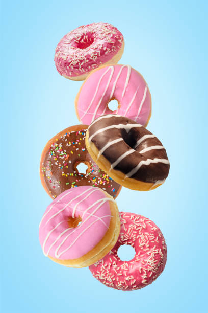 istock Different fresh donuts on blue background. Minimal food concept. 1256105762