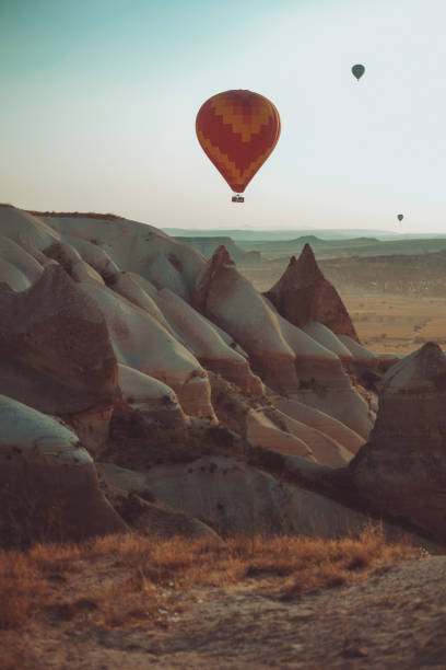 istock Hot air balloon flying over rock formation in Cappadocia 1256107008