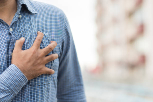 mano hombre en el pecho, apretando su corazón tuvo un ataque cardíaco repentino. - human hand help pain heart attack fotografías e imágenes de stock