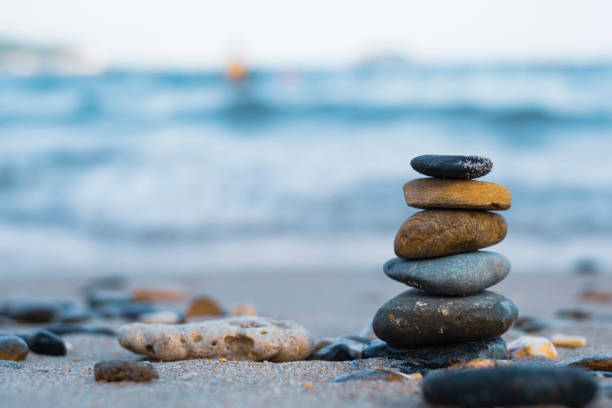 istock Pebbles are piled on a volcanic rock by the sea. Zen concept. Copy space 1256109941