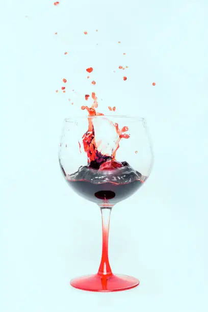 Photograph of a glass of wine with a sky blue background, perfect combination of colors to convey many positive adjectives.