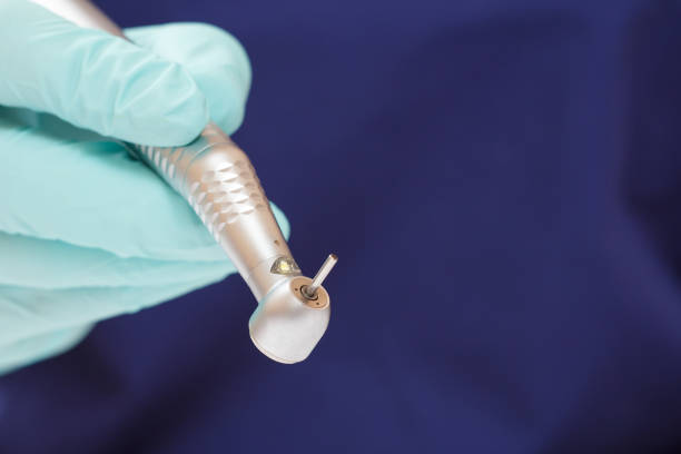 istock Dentist's hand in glove with dental handpiece. 1256112313