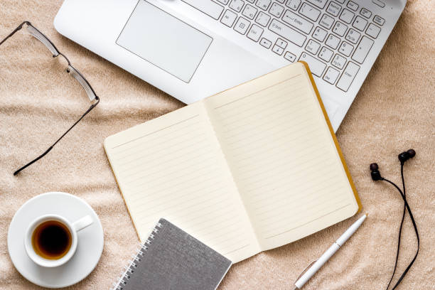 istock working at home on a bed with laptop and notebook from above 1256113291