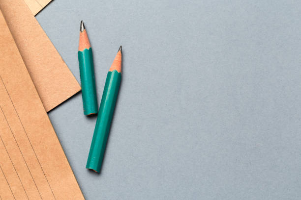 istock Pencils and notepad paper sheets on gray desk table 1256113736